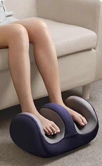 femme assise sur canape massant pieds avec appareil massage pied