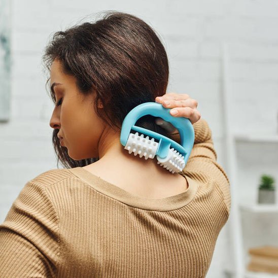 femme debout massant dos avec masseur anticellulite