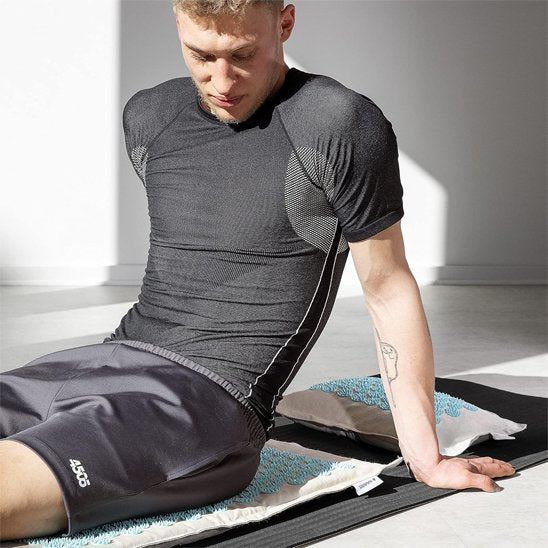 homme assis sur tapis dacupression dans salon